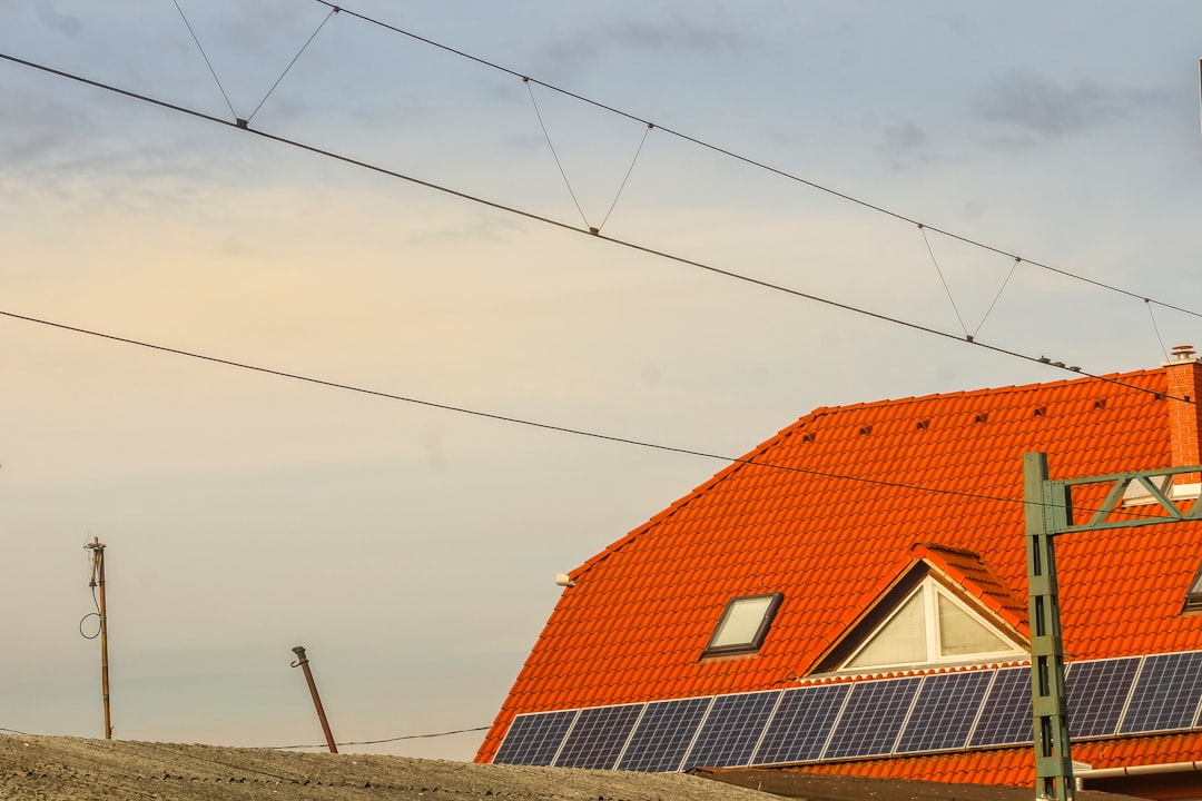 orange-roof-with-solar-panels-and-overhead-wires-iowviwkyjra